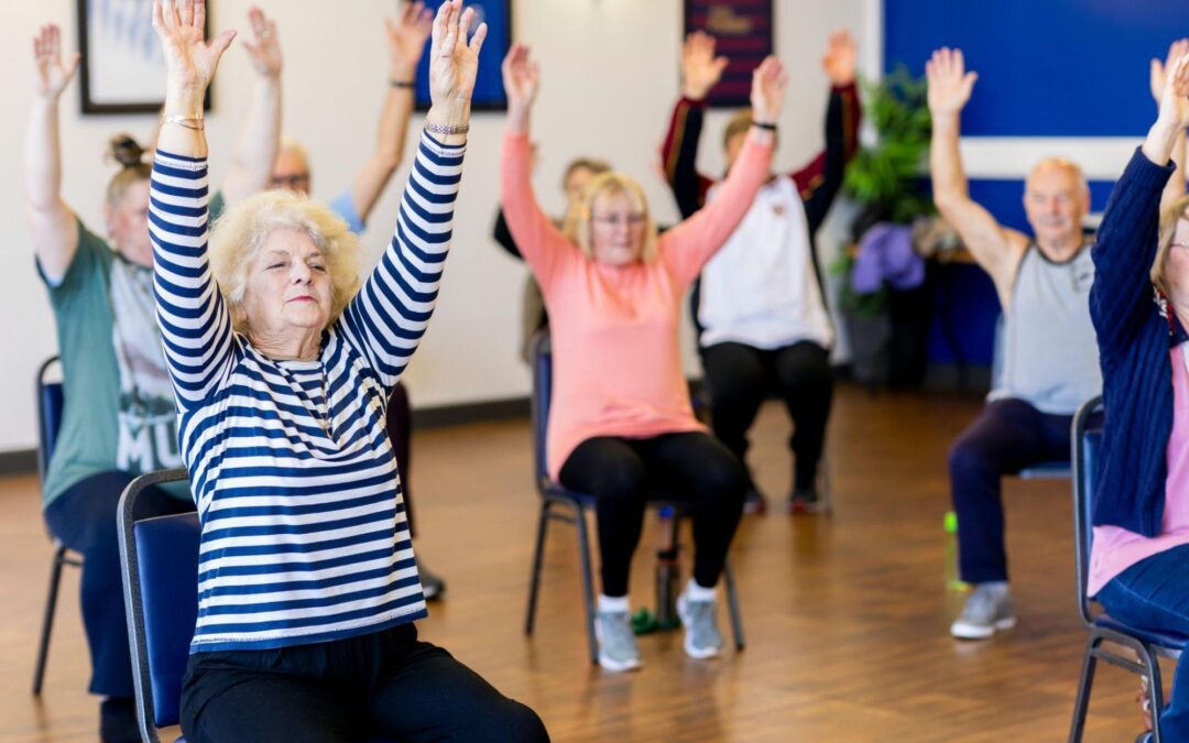 a group of older people doing yoga in a room